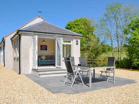 Wonderful holiday home with paved patio area and outoutdoor furniture on the paved patio | Riverside Cottage, Boreland, near Lockerbie