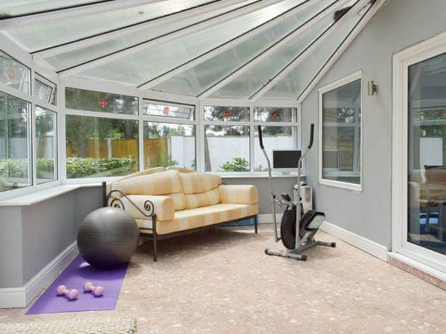 Spacious conservatory with seating and gym equipment | Buttercup Cottage, Halsall, near Ormskirk