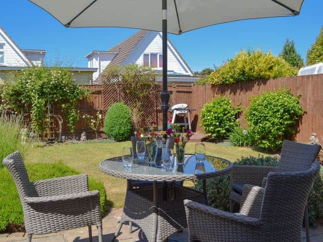 Enclosed lawned garden with patio/ sitting out area | Coastal Dream, Mudeford, near Christchurch