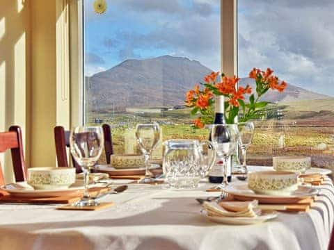 Sunny dining room with dramatic views of the hills | Padraig&rsquo;s Cottage, Howbeg (Tobha Beag), Isle of South Uist