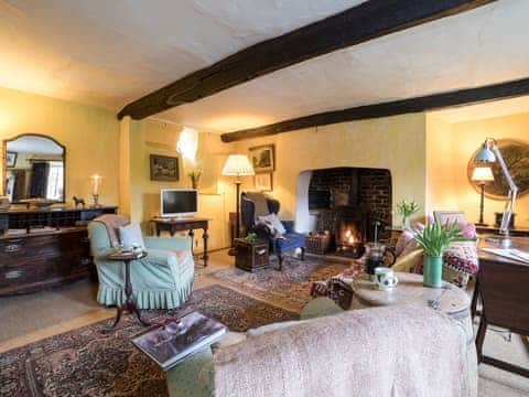 Cosy living room with wood burner | The Old Priory Cottage, Dunster, near Minehead