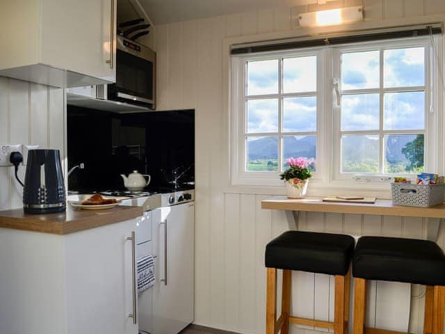 Compact kitchen and adjacent dining area | Skiddaw - Lake View Shepherds Huts, Millbeck, near Keswick