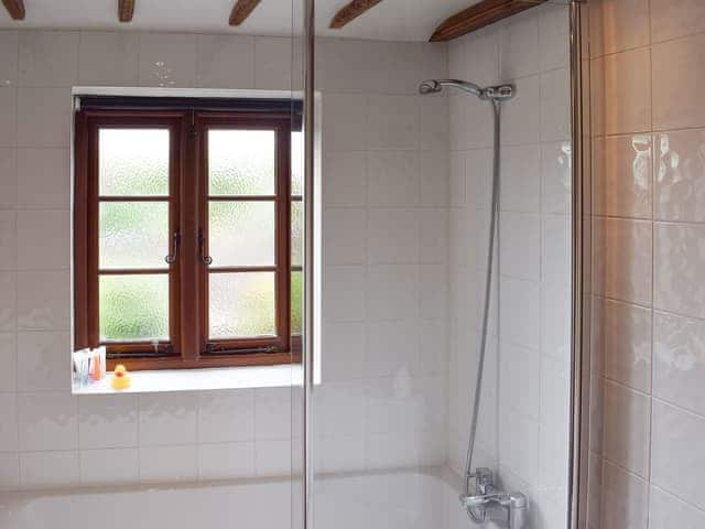 Beamed bathroom with shower over bath | The Old Bakery, Wendover, Aylesbury