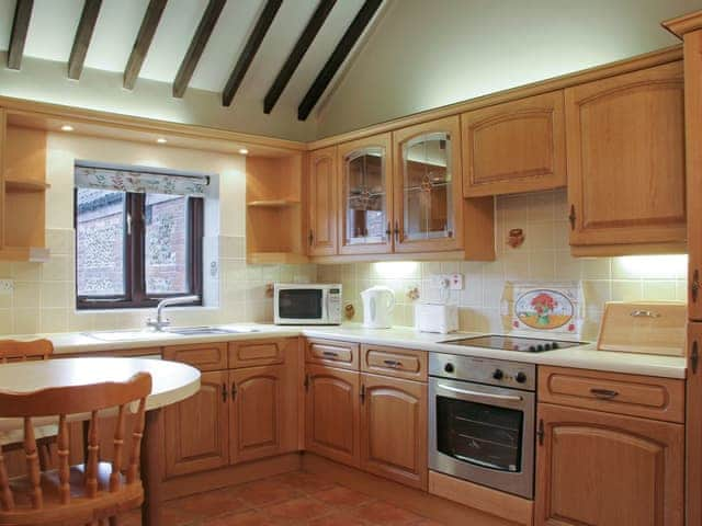 Well-equipped fitted kitchen with exposed wood beams | Littlewoods Barn - Moor Farm Stable Cottages, Foxley, near Fakenham