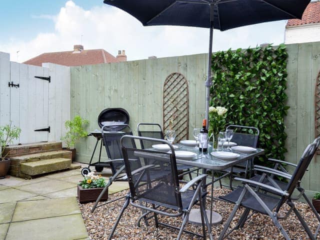 Small enclosed courtyard with sitting-out area, garden furniture and BBQ | The Horseshoes, Hornsea