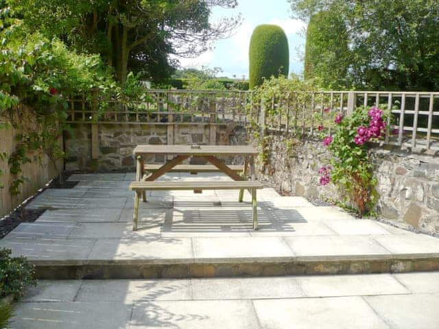 Tranquil patio garden with seating area | Larch Cottage, Dunstan, near Alnwick