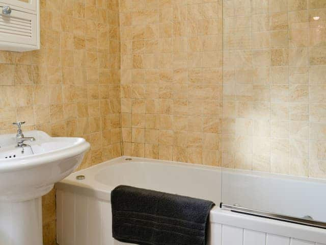 Tiled bathroom with shower over the bath | Thorpe Cottage, Masham