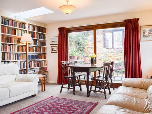 book lined dining area with access to the conservatory | The Blacksmith Shop, Shorwell