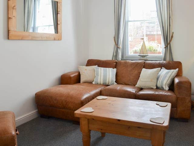 Cosy living room with leather furniture | Lobster Pot Cottage, Scarborough