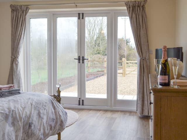 Peaceful double bedroom with French doors to second patio area | Hare&rsquo;s Home - Thursford Holidays, Thursford, near Fakenham