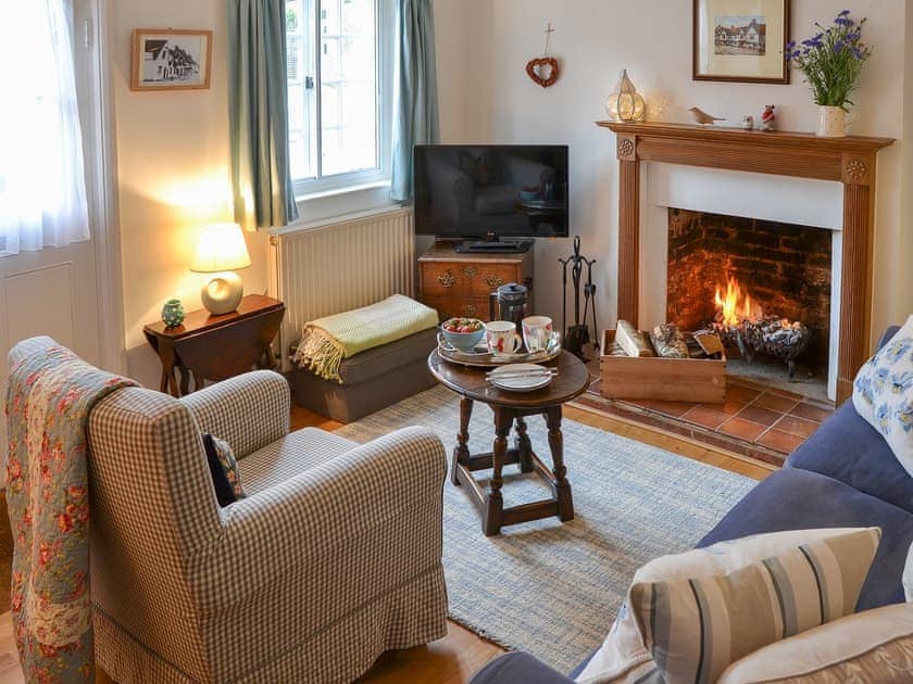 Cosy living room with open fireplace | Lavenham Red Brick Cottage, Lavenham