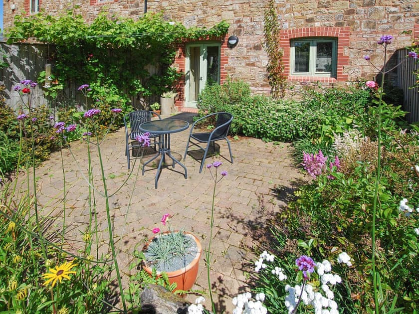 Charming block paved patio area with table and chairs | Ostler&rsquo;s Cottage - Lower Winsford Farm, Halwill Junction, near Beaworthy