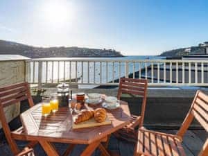 The balcony enjoys a sunny due south aspect and has a particularly stunning outlook over the harbour and the open sea | Waterfront Apartment, Fowey