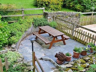 Charming terraced garden to the rear of the cottage with a large picnic table and bench | Mill Cottage, Fowey
