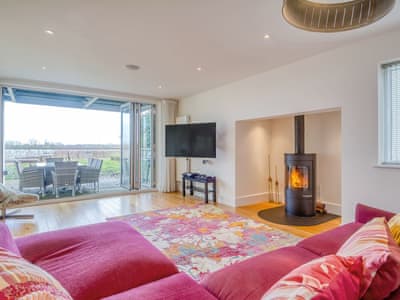 Living room with wood burner and bi-folding doors | Otters View, Somerford Keynes, near Cirencester