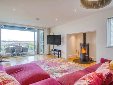 Living room with wood burner and bi-folding doors  | Otters View, Somerford Keynes, near Cirencester