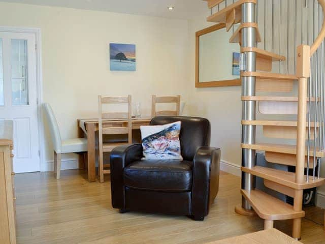 Living/dining area with spiral staircase | Ghillie Cottage, Cockermouth