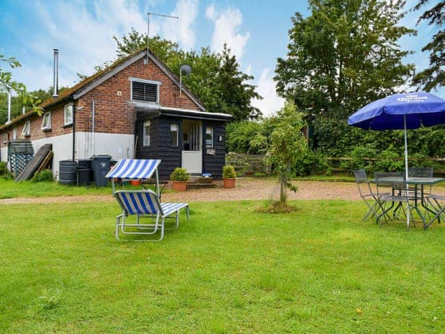 Lawned grounds with sitting-out area and furniture | Evie Rose Cottage, Elsenham, near Bishop&rsquo;s Stortford 