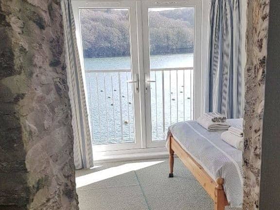 Double bedroom with double doors leading out onto the balcony with lovely river views | Middle Deck, Fowey