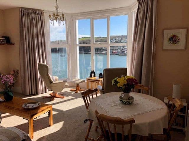 The dining/living area with spectacular views from the large bay window | St Catherines Court No 7, Fowey