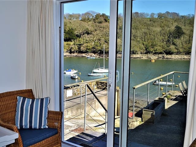 The sitting room has patio doors leading out onto a patio with delightful views of the river | Tarquins, Fowey