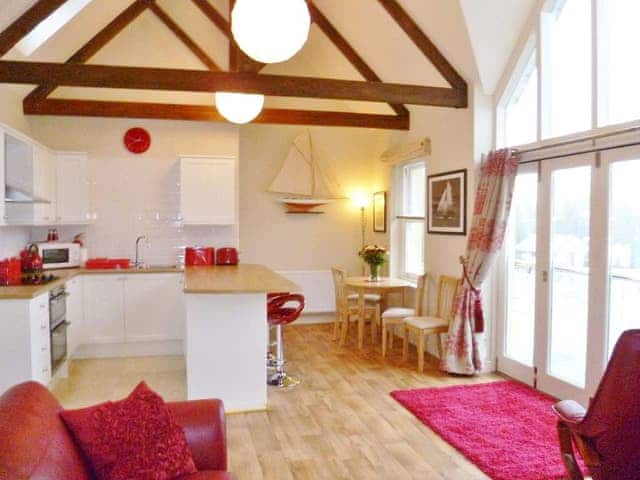 The main open plan living area with a striking feature window with Juliet balcony | Watch House, Fowey
