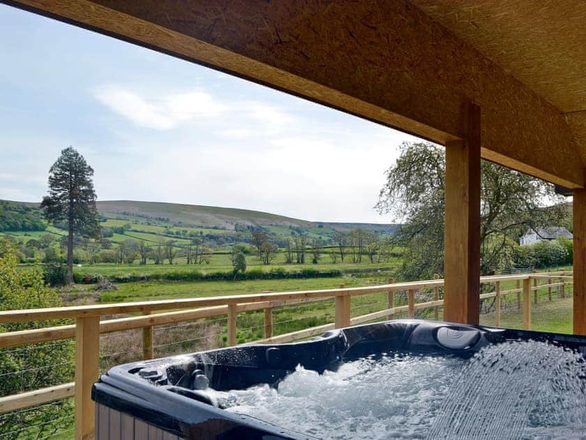 Relaxing hot tub with stunning views | Woodland Lodge - Bryncoch Holidays, Hundred House, near Builth Wells