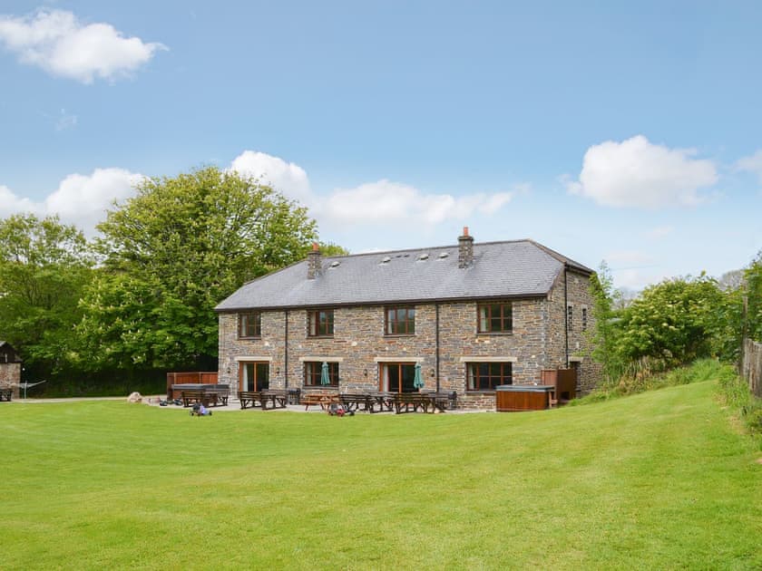 Garden and patio with hot tub and picnic style seating | Elderberry House - Sherrill Farm Holiday Cottages, Dunterton, near Tavistock