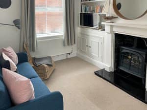 Comfortable living room with wood effect electric fire | Evelyn Cottage, Dartmouth