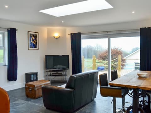 Inviting living area with patio doors leading to decking | Gatsby Getaway, Kentisbury, near Ilfracombe
