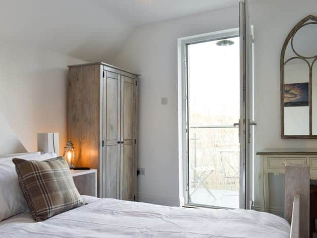 Peaceful double bedroom with door to balcony | Abbey View, Whitby