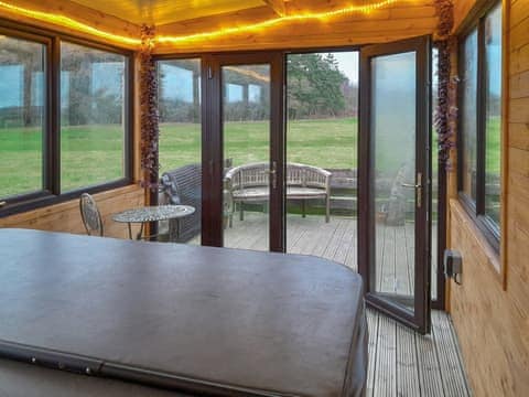 Large Hot tub which includes one lounger overlooking open fields and woodland. Ideal for enjoying Dumfries and Galloways | Trebor Cottage, Annan, near Dumfries