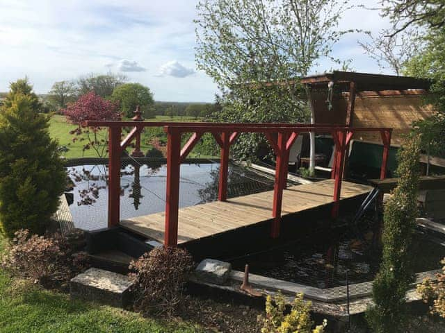 Koi pond sitting area. | Cedar Lodge, Cowbeech, near Hailsham