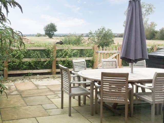 Patio area with mature hedge and shrubs. | Lords View, Ruckinge, near Ashford