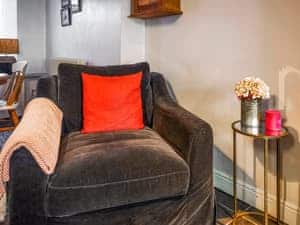 Large comfortable love seat armchair in living room | Mill Cottage, Gosforth