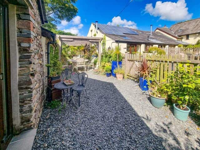 Charming seated area with outdoor table and chairs | Stonecroft Cottage - Wreaks End Farm, Broughton-in-Furness