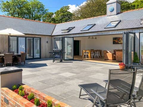 South facing patio with BBQ, garden furniture and hot tub | Manor Lodge Stables, Wiston, near Haverfordwest