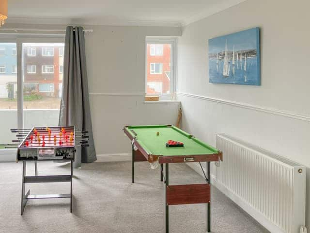 First floor landing - snooker and football table plus a selection of books. Patio doors leading to the south facing balcony with sea glimpses. | Poppy&rsquo;s by the sea, Hayling Island