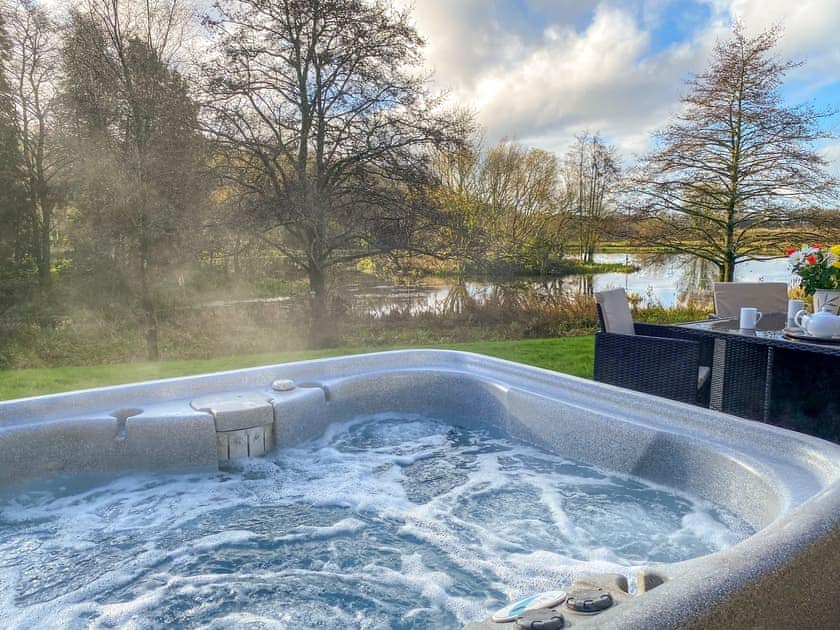 Hot tub with stunning views over the lake | Wren Cottage - Maesydderwen Holiday Cottages, near Llandeilo