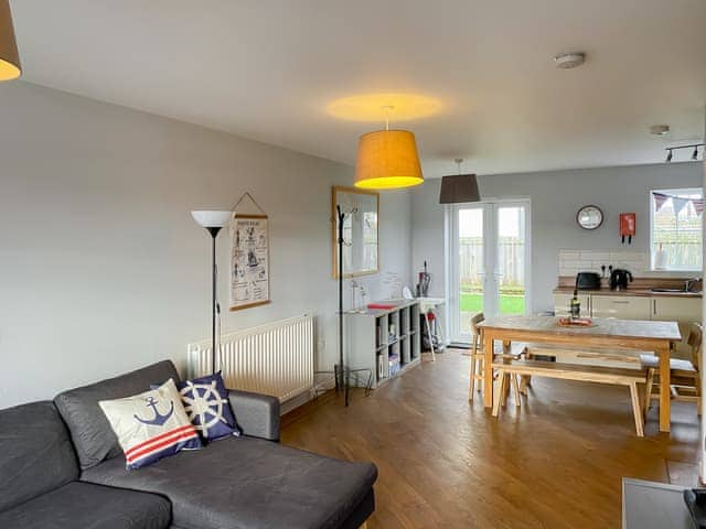 Comfy seating in living area of open-plan living space | Cowry Cottage, Beadnell