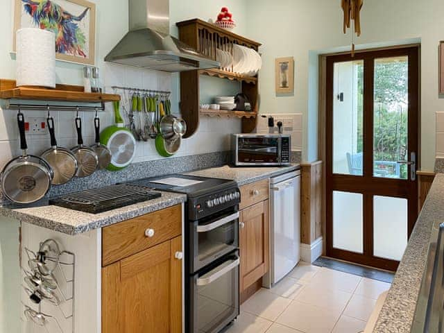 The kitchen affords access to the veranda&rsquo;s swing seat, outdoor dining area and garden | The Headmaster&rsquo;s Cottage, South Hill, near Tamar Valley