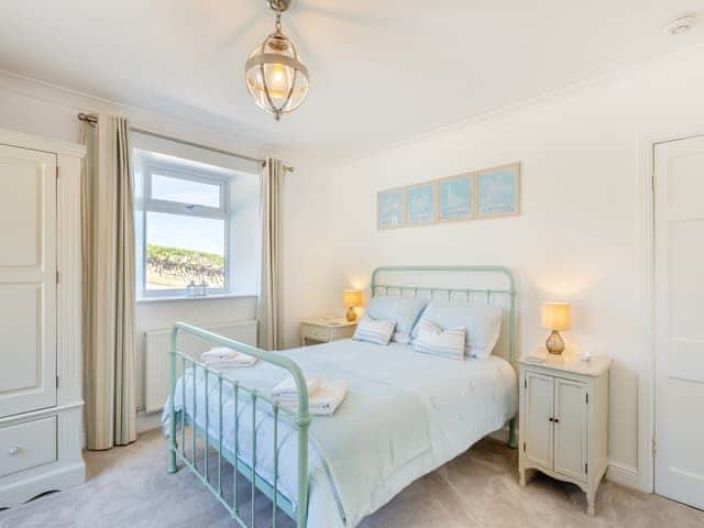 The lovely dual aspect kingsize bedroom with pretty Laura Ashley fabrics and padded windowseat | Tregarrek, Helston & The lizard