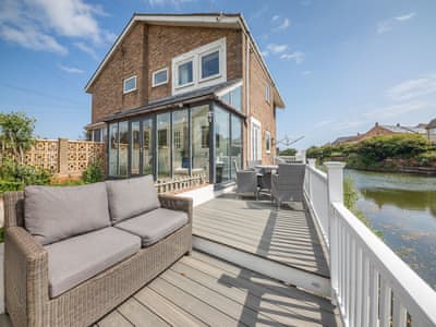 Entrance and one of 3 seating areas | Water’s Edge Holiday Home, Beadnell