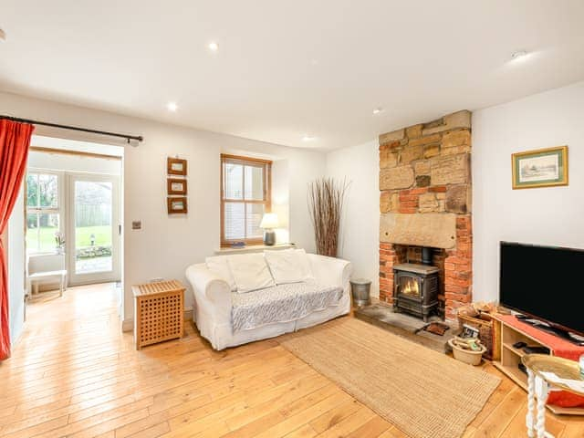 Relaxing seating with woodburning stove and TV | Bumble Cottage, Newton-on-the-Moor, near Alnwick