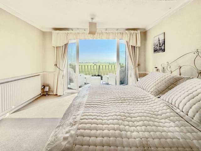 Master bedroom leading onto a balcony with stunning views over the protected marshland fields and Ribble Estuary | High Mill House, Freckleton