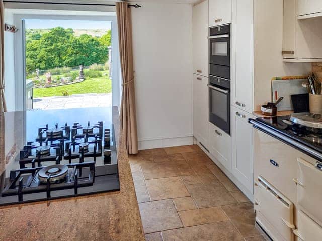 Kitchen with aga, looking onto garden | Dunstone Cottage, Cadover Bridge
