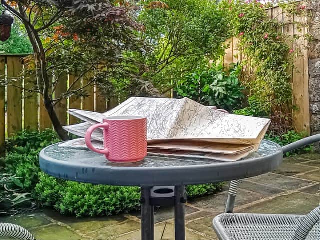 Private pretty courtyard with furniture and birdfeeders | School Cottage, Newbiggin-in-Bishopdale, near Leyburn