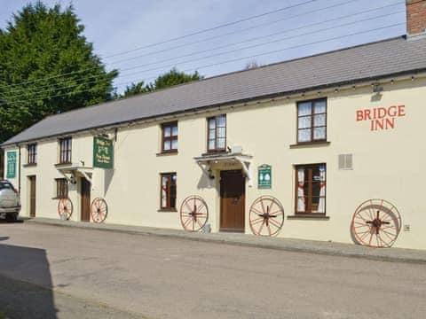 The flat is on the upper floor of the Bridgerule village pub on the left of the image  | The Bridge Inn Apartment, Bridgerule, near Bude