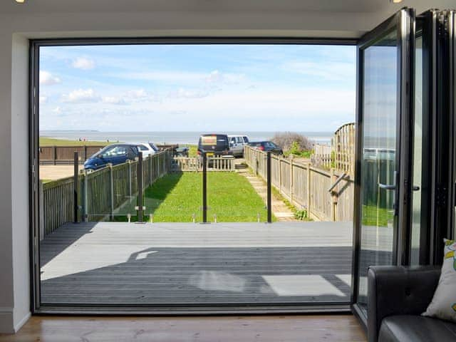 Bi-fold doors opening onto decking with wonderful views overlooking the Thames Estuary. | Coastguard Cottage, Swalecliffe, near Whitstable