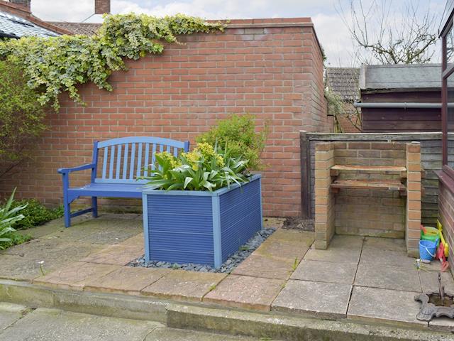 Seating area and built-in BBQ within rear garden | Beach Cottage, Winterton-on-Sea